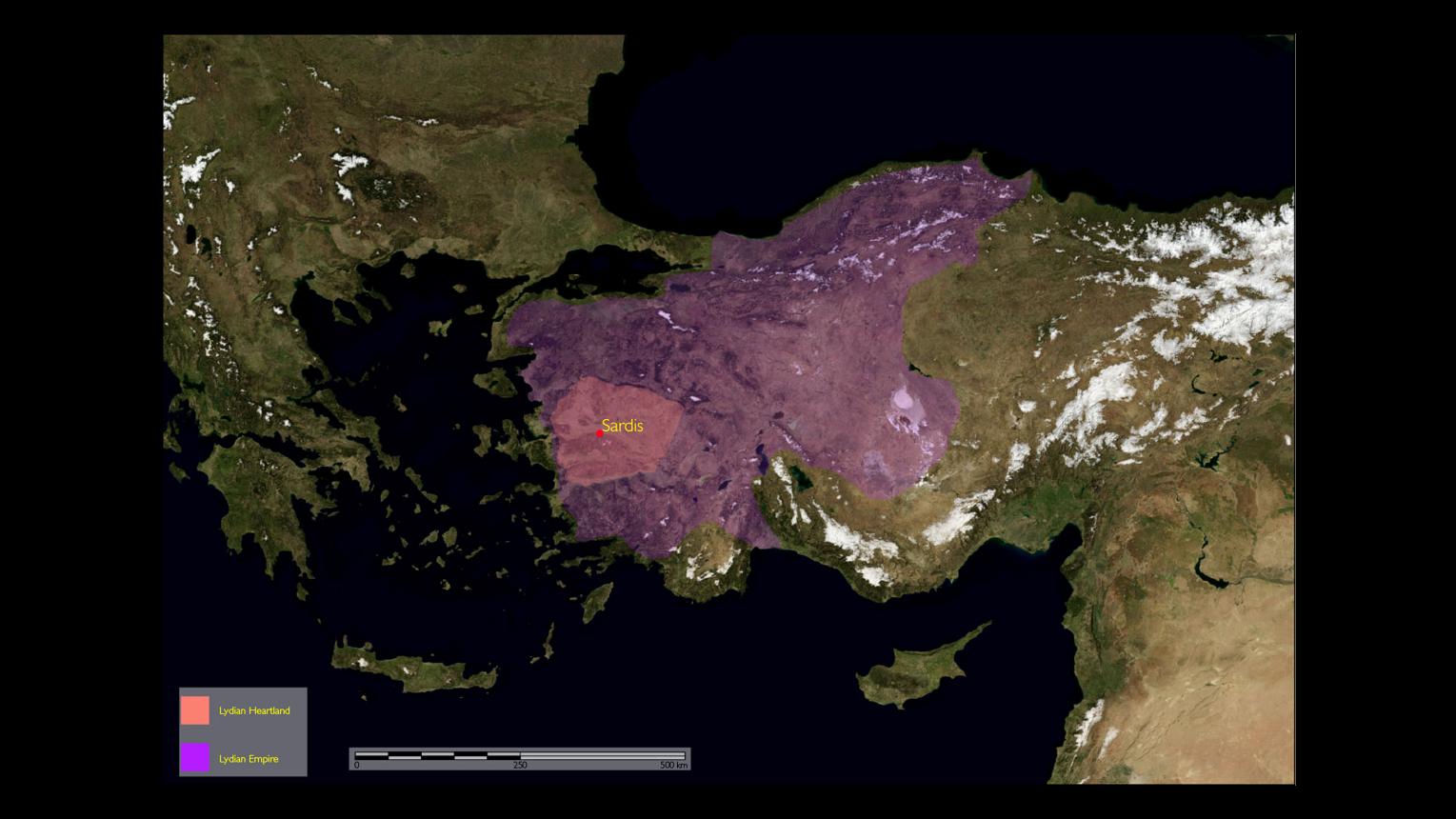 Image of second power point slide. Slide contains photo of topographical map. On the map there is a purple area referenced as the Lydian Empire, inside the purple area there is a smaller pink area labeled Lydian Heartland. In the very center of these two areas is a red dot denoting the site of Sardis.